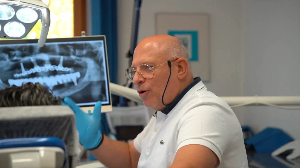 Dr. Mihail erklärt ein Panorama-Röntgenbild mit implantatgetragenem Zahnersatz