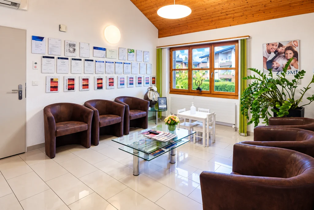 Wartebereich mit Ledersesseln, Kinderecke und Urkunden an der Wand