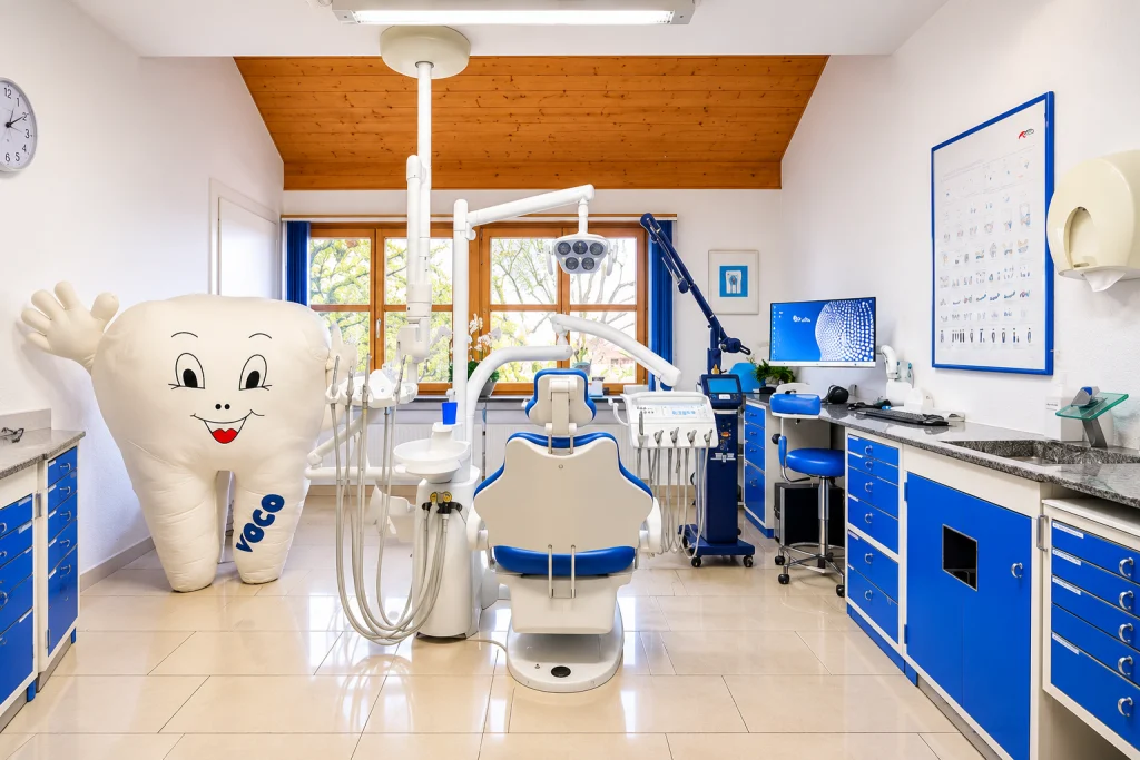 Behandlungszimmer mit blauen Schränken, Holzdecke und einem grossen Plüschzahn als Maskottchen