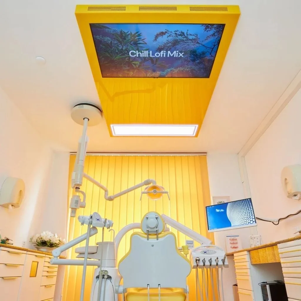 Behandlungszimmer mit einem Bildschirm über dem Behandlungsstuhl